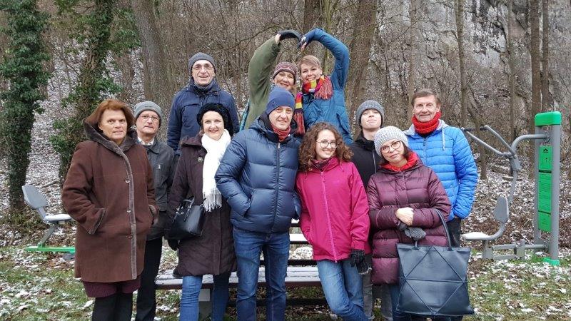 Gruppen von Menschen vor einer Sitzbank